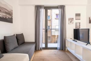 ein Wohnzimmer mit einem Sofa und einem TV in der Unterkunft CENTRIC APARTMENT CAMP NOU 2 in Hospitalet de Llobregat
