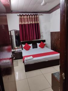 een slaapkamer met een bed met rode kussens bij evergreen family homesty in Agra