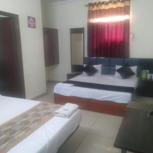 een hotelkamer met 2 bedden en een rood gordijn bij evergreen family homesty in Agra