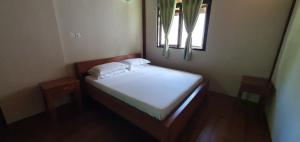 a small bed in a room with a window at HideAway in Praslin