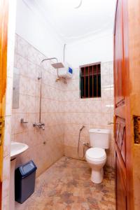 a bathroom with a toilet and a sink at Seven Ranges Hotel in Moroto