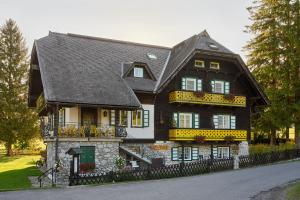 a black and white house with a black roof at Hotel Harrida in Weissensee