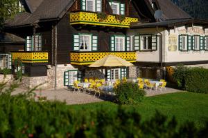 a house with a table and chairs in front of it at Hotel Harrida in Weissensee