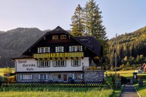 a building with a sign on the side of it at Hotel Harrida in Weissensee
