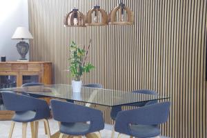 ein Esszimmer mit einem Tisch und blauen Stühlen in der Unterkunft LA MANSARDE in Aix-les-Bains