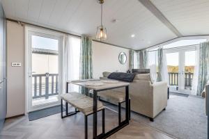 a living room with a couch and a table at Lodge No 9 - St Andrews Lodge Park in Strathkinness