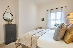 een slaapkamer met een bed met een spiegel en een raam bij Host & Stay - Salty Bay in Saltburn-by-the-Sea