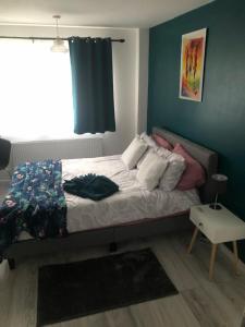 a bed in a bedroom with a blue wall at Bree and Geesi in Birmingham