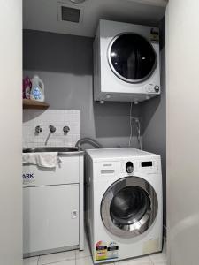 a kitchen with a washing machine and a microwave at Charming Peaceful 3BR in heart of Rhodes in Sydney