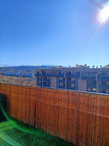 a red fence with a building in the background at Acogedora habitación privada en Villa Mayka in Granada