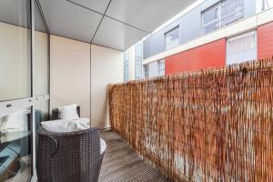 a room with a wicker chair and a brick wall at Charming & Large 1-Bedroom in the Heart of London in London