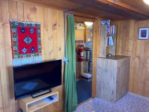 een woonkamer met een tv en een kamer met een brandkraan bij Chalet Alphütte in Rosswald