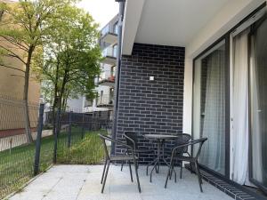 patio ze stołem i krzesłami na balkonie w obiekcie Apartamenty Wrzeszcz by Q4Apartments w Gdańsku