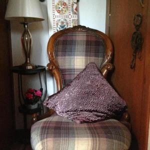 a pillow sitting on a chair with a lamp at Beautiful House in Village Newburgh Ellon in Ellon