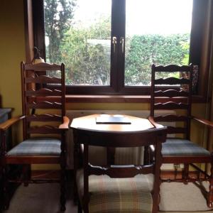 2 Stühle und ein Tisch vor einem Fenster in der Unterkunft Beautiful house in village Newburgh Ellon in Ellon
