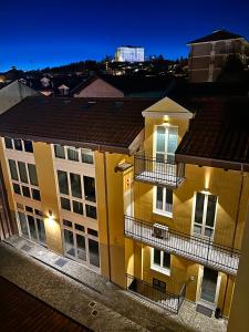 un edificio amarillo con 2 balcones por la noche en Piol42 - Affitti Brevi Italia, en Rivoli