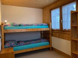 two bunk beds in a room with a window at Chalet Gerbera in Rosswald