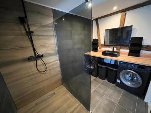 baño con lavadora y TV en Douce évasion en Beinheim