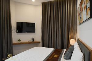 a hotel room with a bed and a flat screen tv at MINH ANH HOTEL in Can Tho