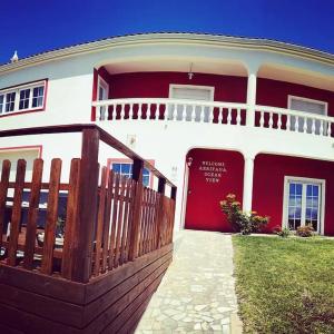 una casa rossa e bianca con una recinzione in legno di Moradia Arrifana Ocean View ad Aljezur Altre 39 foto