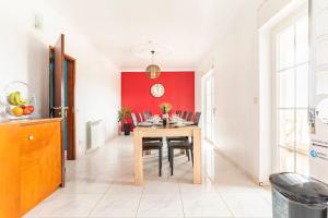 una sala da pranzo con tavolo e parete rossa di Moradia Arrifana Ocean View ad Aljezur