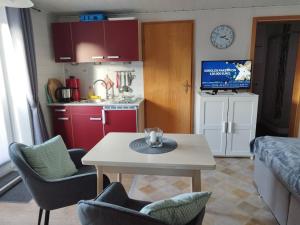 a living room with a table and chairs and a kitchen at FeWo 3 mit Terrasse, Box-Bett, kl extra Zi mit Einzelbett, Tresor in Dahme