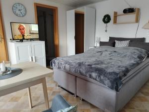 a bedroom with a bed and a table and a clock at FeWo 3 mit Terrasse, Box-Bett, kl extra Zi mit Einzelbett, Tresor in Dahme