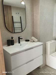 ein Badezimmer mit einem weißen Waschbecken und einem Spiegel in der Unterkunft ESTUDIO d'PACO in Callosa d'en Sarrià