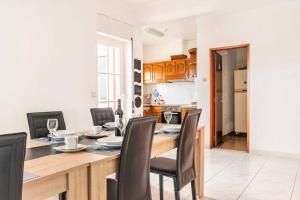una cucina e una sala da pranzo con tavolo e sedie in legno di Moradia Arrifana Ocean View ad Aljezur