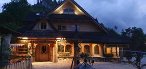 a large house with lights on the front of it at Gospoda Harnaś in Kościelisko