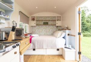 a small bedroom with a bed in a tiny house at Blossom in Sherborne