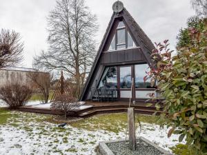 une maison avec un toit de chaume dans un jardin dans l'établissement Seeblick, à Immenstaad am Bodensee