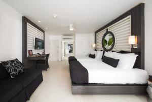 a bedroom with a large bed and a couch at S Hotel Montego Bay - Luxury Boutique All-Inclusive Hotel in Montego Bay