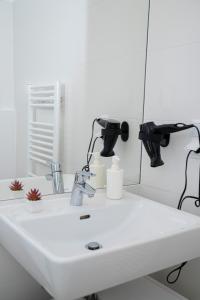 y baño con lavabo blanco y espejo. en CENTRAL Stephansdom apartment I Netflix I Self Check In en Viena