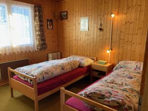 a bedroom with two beds and a window at Chalet Bambi in Rosswald