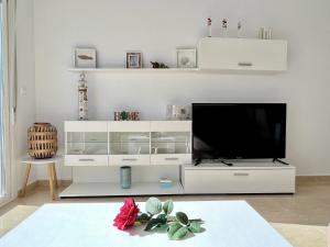 a white entertainment center with a flat screen tv at Dunas Home by Gloove in Gran Alacant