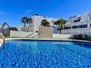 a large blue swimming pool in front of a building at Dunas Home by Gloove in Gran Alacant