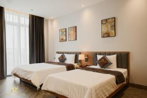 a hotel room with two beds and a window at MINH ANH HOTEL in Can Tho