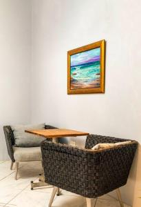a table and a chair in a room with a picture on the wall at Tides Lobitos in Lobitos