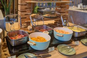 a buffet with bowls of food on a table at DoubleTree by Hilton Porto Alegre in Porto Alegre