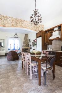 uma cozinha com uma mesa de jantar e cadeiras em Casa di campagna em Faskomiliá