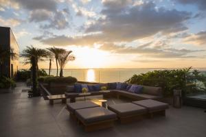 a living room with a couch and tables and a sunset at DoubleTree by Hilton Porto Alegre in Porto Alegre