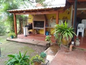 聖佩德羅克拉拉的住宿－Cabaña El Abuelo，一个带壁炉和植物的门廊