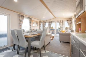 a kitchen and dining room with a table and chairs at Lodge 2 The Silverdale Close to St Andrews in Strathkinness