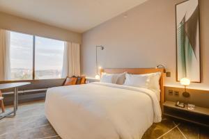 a bedroom with a large white bed and a table at DoubleTree by Hilton Porto Alegre in Porto Alegre