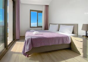 a bedroom with a large bed with a purple blanket at Azize Palas Apart Otel in Izmir
