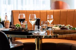 uma mesa com dois pratos de comida e taças de vinho em DoubleTree by Hilton Cheltenham em Cheltenham