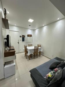 Zimmer mit einem Tisch, einer Küche und einem Schlafzimmer in der Unterkunft Biquinha - Praça 22 de Janeiro in São Vicente