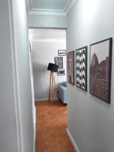 a hallway with paintings and a lamp on a wall at Magnífico apartamento in Rio de Janeiro