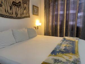 een slaapkamer met een wit bed met een raam bij Casablanca Guest Inn in Takoradi